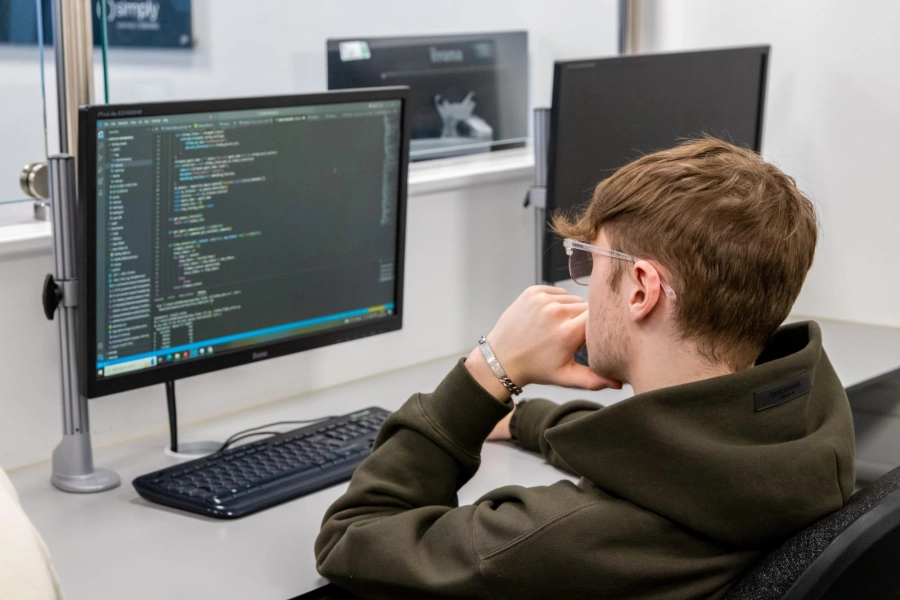 Student coding on computer in a classroom