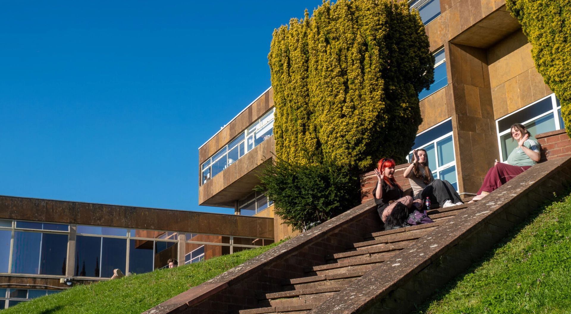 Rear of All Saints Building with students on the steps