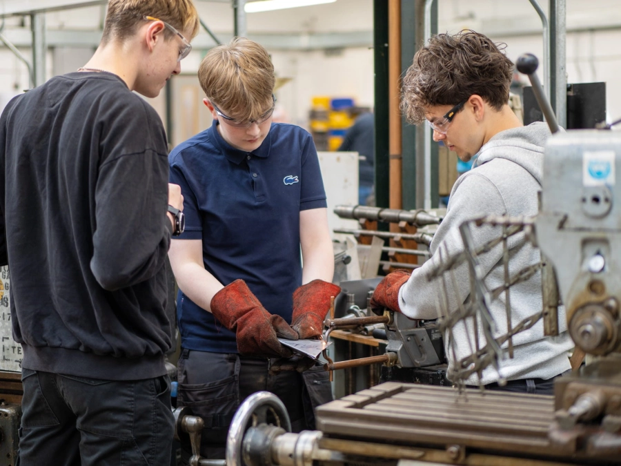 Students working on engineering equipment  in workshop