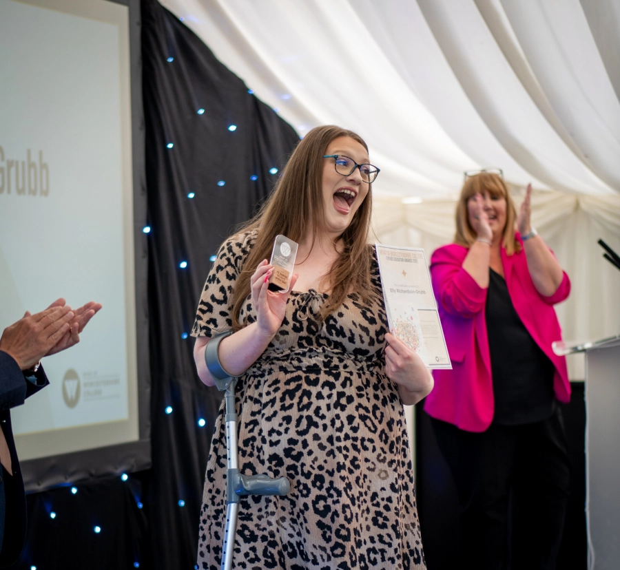 Student receiving an award at JHW College ceremony and celebrating