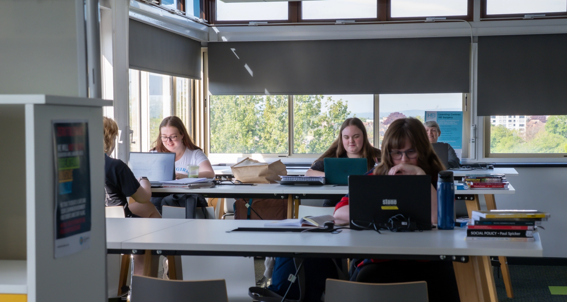 Group of students at desks on laptops jpg