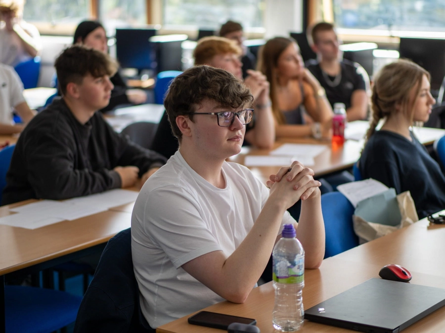 Students in a classroom sat at desks listening