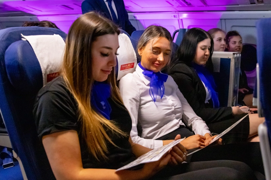 Students reading information whilst sat on a seat in the mock air cabin