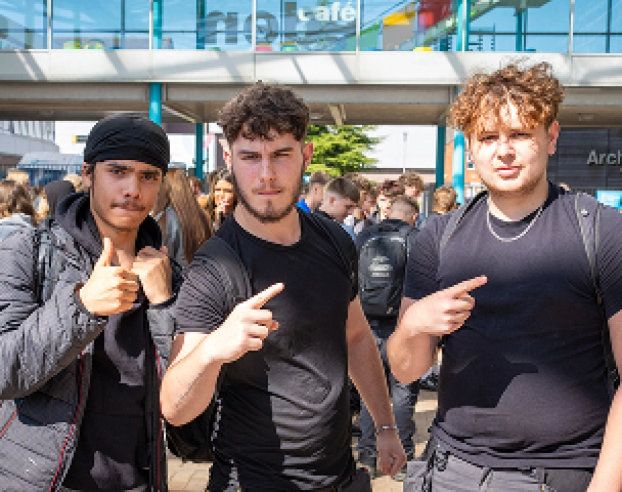 3 students posing for a photo outside of campus