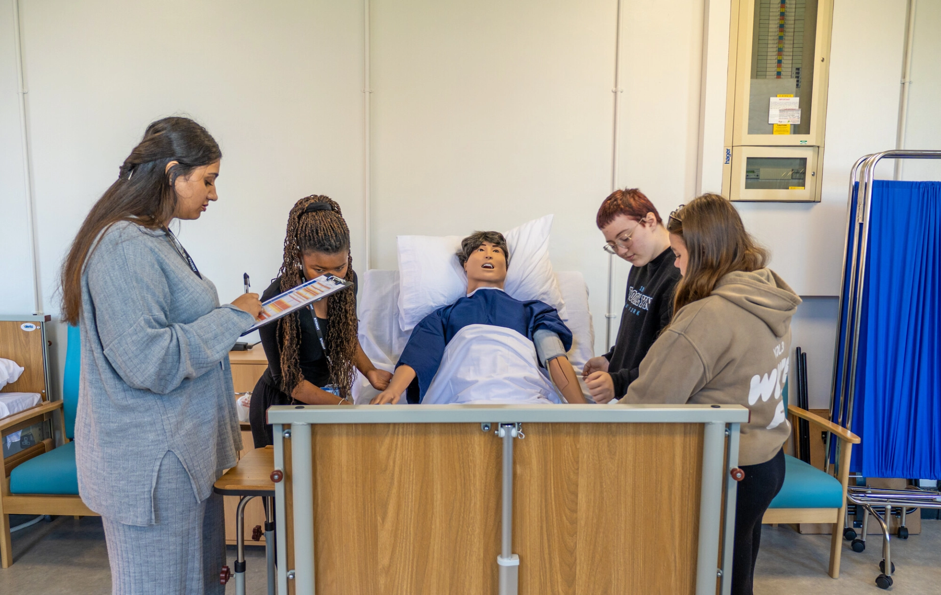 Students getting practical experience in the Colleges mock ward by working on a manequin